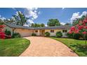 Charming single-story home with brick driveway, lush lawn, and blooming crape myrtle trees at 2491 Island Dr, Longwood, FL 32779