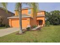 Two-story home with a two-car garage and landscaping in a well-maintained front yard at 2660 Santosh Cv, Kissimmee, FL 34746