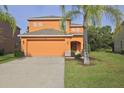 Two-story home with a two-car garage and landscaping in a well-maintained front yard at 2660 Santosh Cv, Kissimmee, FL 34746