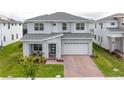 Charming two-story home featuring a covered front porch, an attached two-car garage and a lush green lawn at 2841 Willowseed Ln, St Cloud, FL 34772