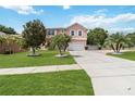 Charming two-story home with lush landscaping, palm trees, and a spacious driveway at 294 Hunt St, Clermont, FL 34711