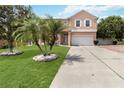 Inviting two-story home with manicured lawn and stone-lined palm trees at 294 Hunt St, Clermont, FL 34711