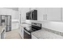 Modern kitchen featuring stainless steel appliances, granite countertops, and white cabinets at 354 Miller Rd, Sanford, FL 32773