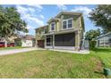 Two-story home with a well-maintained lawn, screened front porch, and a two car garage at 3842 Klondike Pl, Sanford, FL 32771