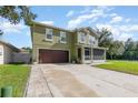 Two-story home with a well-maintained lawn, screened front porch, and a two car garage at 3842 Klondike Pl, Sanford, FL 32771