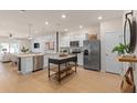 Modern kitchen with stainless steel appliances, white cabinets, and an island at 393 Meadowland Pt, Oviedo, FL 32765
