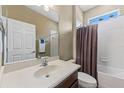 Bathroom featuring a large mirror, neutral tile, and a shower-tub combination at 4813 River Gem Ave, Windermere, FL 34786