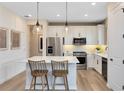 Modern kitchen features stainless steel appliances, sleek white cabinets, pendant lighting, and center island at 5158 Gardenrow Dr, St Cloud, FL 34772
