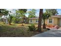 Exterior view of a home with fresh landscaping, trees, and a well-maintained lawn at 7600 Skyview Dr, Orlando, FL 32809