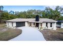 Charming single-story home with a well-manicured lawn and a long, paved driveway at 817 Helen Ave, Deland, FL 32720