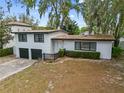 Two-story home with a 2-car garage, dark trim and a concrete driveway at 913 Moss Ln, Winter Park, FL 32789