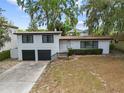 Two-story home with a 2-car garage, dark trim and a concrete driveway at 913 Moss Ln, Winter Park, FL 32789
