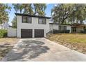 Two story home with a two car garage, a long driveway, and mature shade trees at 913 Moss Ln, Winter Park, FL 32789