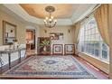 Formal dining room featuring a decorative ceiling, elegant chandelier, and large windows for natural light at 108 Sagecrest Dr, Ocoee, FL 34761