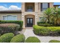 Elegant front entrance with glass paneled door and well-maintained landscaping, leading to a welcoming home at 108 Sagecrest Dr, Ocoee, FL 34761