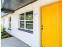 Close-up of a vibrant yellow front door and adjacent window showcasing the house number, 1105 at 1105 Valencia Ave, Haines City, FL 33844