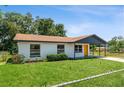 Attractive single-story home with a fresh exterior paint job, a yellow door, and a well-manicured front lawn at 1105 Valencia Ave, Haines City, FL 33844