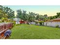 Grassy backyard featuring mature trees, storage shed and play equipment, perfect for outdoor enjoyment at 12381 Antonio Cir, Orlando, FL 32826