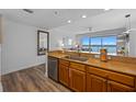 Modern kitchen featuring stainless steel appliances, wood cabinets, granite countertops and a view of the living area at 13415 Blue Heron Beach Dr # 710, Orlando, FL 32821