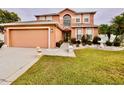 Charming two-story home with a manicured lawn and a two-car garage at 16041 Lagoon Dr, Clermont, FL 34711