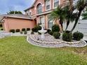 A two-story home with a well-manicured lawn and a water fountain at 16041 Lagoon Dr, Clermont, FL 34711