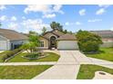 Inviting single-story home with a manicured lawn, brick-lined walkway, and a convenient two-car garage at 219 Old Mill Cir, Kissimmee, FL 34746