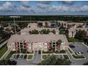 Aerial view of colorful apartment complex and beautiful landscape with pond in the background at 2208 Antigua Pl # 932, Kissimmee, FL 34741