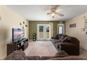 Comfortable living room with neutral carpet and a ceiling fan, with access to the backyard at 225 Indiana St, Leesburg, FL 34748