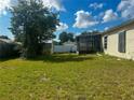 Large backyard with green grass, screened in porch, shed and privacy fence at 3123 Tamarind Dr, Edgewater, FL 32141