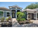 The house's front entrance boasts detailed trim work, a brick walkway, and well-kept landscaping at 3697 Rolling Hills Ln, Apopka, FL 32712