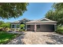 The house has a three-car garage, a brick driveway, and an American flag for added character at 3697 Rolling Hills Ln, Apopka, FL 32712