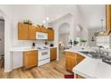 Kitchen boasts wood cabinets, white appliances, a breakfast bar, and an open layout to the dining area at 4640 Eagle Peak Dr, Kissimmee, FL 34746