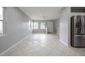Open-concept living room featuring neutral paint, tile flooring, and ample natural light at 4824 Shoshone St, Orlando, FL 32819
