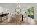 Elegant dining area with a glass-top table and stylish chairs, bathed in natural light from the sliding glass door at 5079 Royal Point Ave, Kissimmee, FL 34746