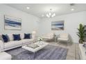 Bright living room with white sofa, stylish decor, and neutral walls, perfect for relaxing or entertaining guests at 5079 Royal Point Ave, Kissimmee, FL 34746