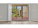 View from inside of sliding glass door onto outdoor balcony with terracotta tiling and outdoor seating at 514 Orange Dr # 31, Altamonte Springs, FL 32701