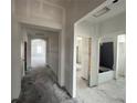 Unfinished hallway view showcasing the home's layout with multiple rooms and an archway to a room with windows at 5250 Teirgarten St, St Cloud, FL 34771