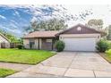 Charming home with a well-maintained front yard, attached garage and covered entry at 5311 Ansonia Ct, Orlando, FL 32839