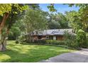 Inviting single-story brick home with solar panels, lush greenery, and a well-maintained lawn at 628 Riverpark Cir, Longwood, FL 32779