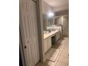 Spacious bathroom with double sinks, tile floors, and glass-enclosed shower stall at 6450 Alcalde Ct # 106, Orlando, FL 32835