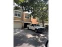 Townhome exterior featuring a white pickup truck parked in the driveway and mature landscaping at 6450 Alcalde Ct # 106, Orlando, FL 32835