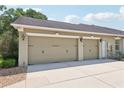 Spacious three-car garage with decorative carriage lights and a smooth concrete driveway at 6686 Se 135Th St, Summerfield, FL 34491