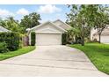 Suburban home with a two-car garage, mature landscaping, and a long driveway at 811 Wayne Ave, Altamonte Springs, FL 32701