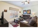 Relaxing living room boasts neutral tones, plush seating, ceiling fan and ample natural light at 8941 Bismarck Palm Rd, Kissimmee, FL 34747