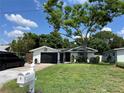 Inviting single-story home with a manicured lawn, mature tree, and a screened-in garage at 1203 Monterey Dr, Eustis, FL 32726