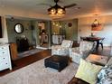 Cozy living room featuring hardwood floors, comfortable seating, and a stylish ceiling fan at 1203 Monterey Dr, Eustis, FL 32726
