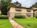 Tan two-story home with dark shutters and a sidewalk leading to the entrance at 130 Jasmine Woods Ct # 3D, Deltona, FL 32725