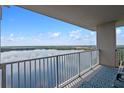 Enjoy stunning waterfront views from this spacious balcony featuring a stylish outdoor rug and comfortable seating at 13427 Blue Heron Beach Dr # 1907, Orlando, FL 32821