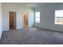 Bright, carpeted bedroom with natural light and ensuite bathroom and walk-in closet entries at 1392 Dalkeith Cv, Sanford, FL 32771