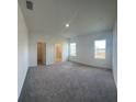 Spacious bedroom featuring neutral carpet, ample natural light, and ensuite bathroom and closet entries at 1392 Dalkeith Cv, Sanford, FL 32771